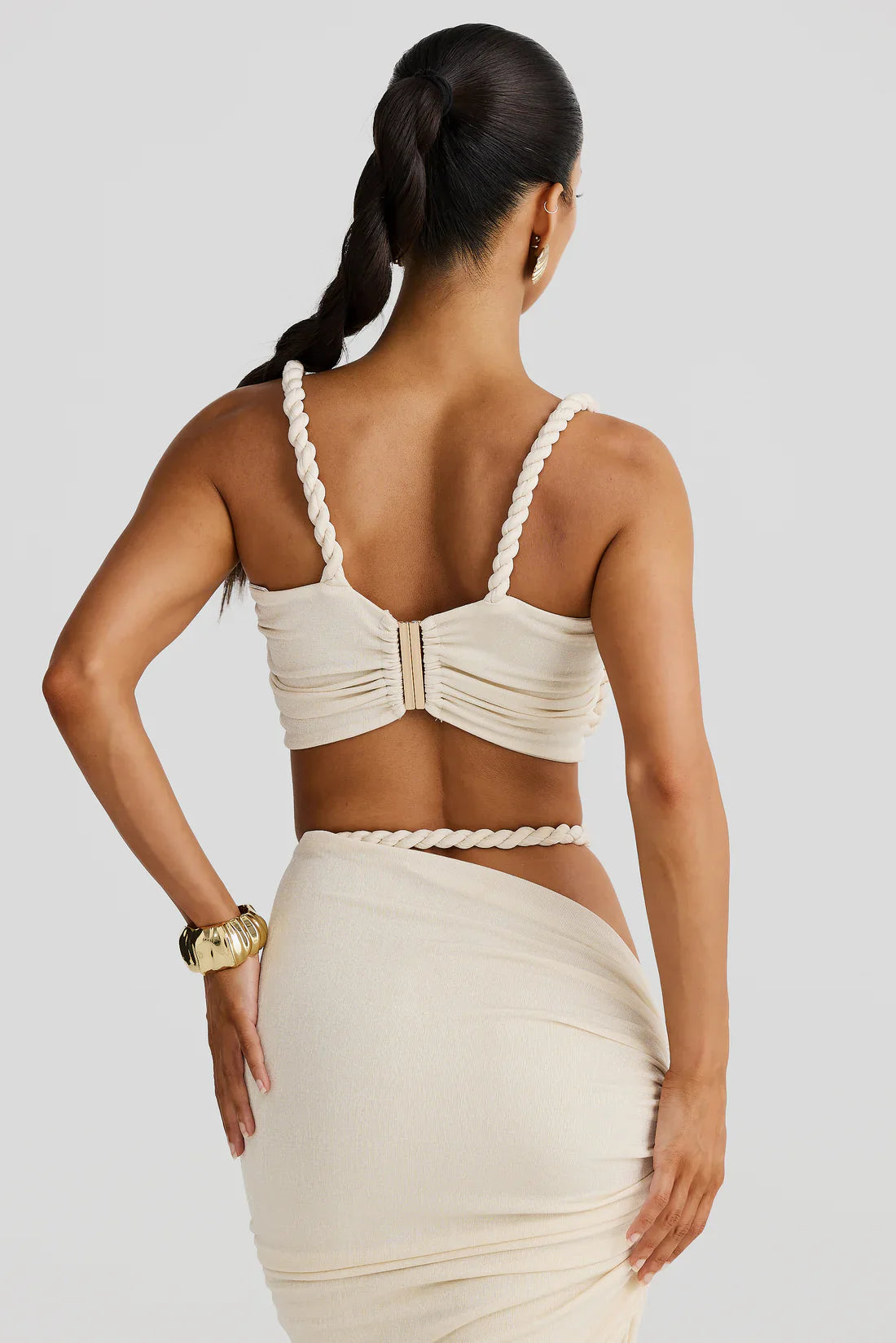 Back view showing cream rope strap bralette with center clasp and high-waist maxi skirt set