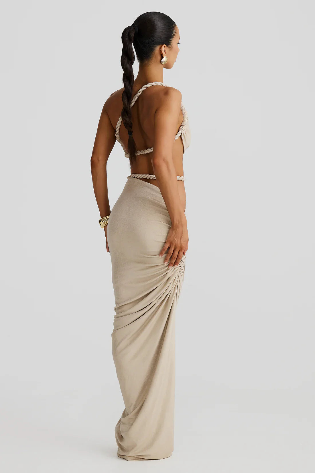 Side back full-length view of cream two-piece maxi skirt set with ruched drape and rope straps